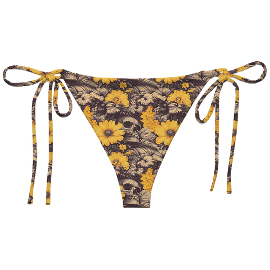 back view of string bikini bottoms swimsuit Deadly Petals which features a surreal collision of vivid golden blooms and shadowy skulls hidden in a jungle of inked leaves