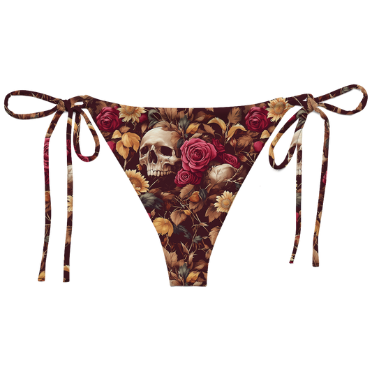 memento bloom string bikini bottoms featuring hauntingly beautiful skulls with lush, full-bodied roses and golden sunflowers against a rich burgundy backdrop